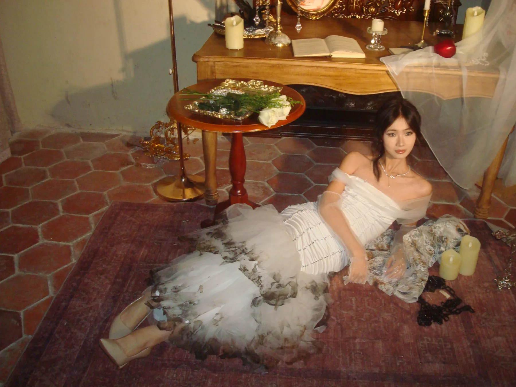Model seated in a layered translucent white garment